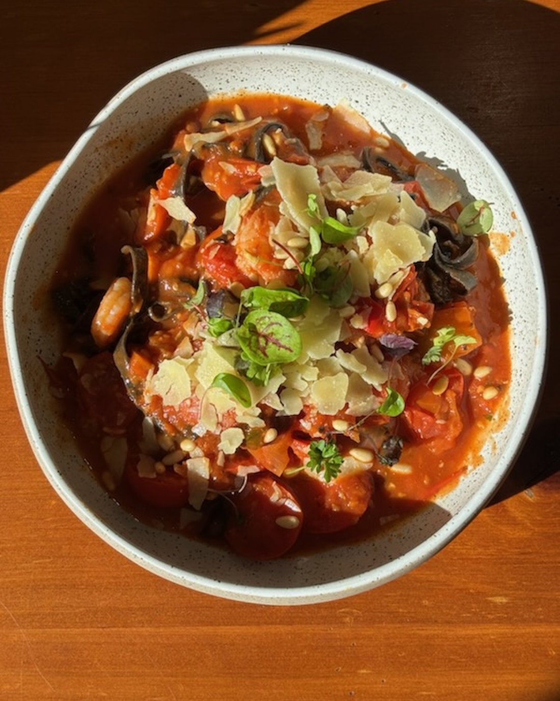 Seafood tomato stew with prawns, parmesan and pine nuts
